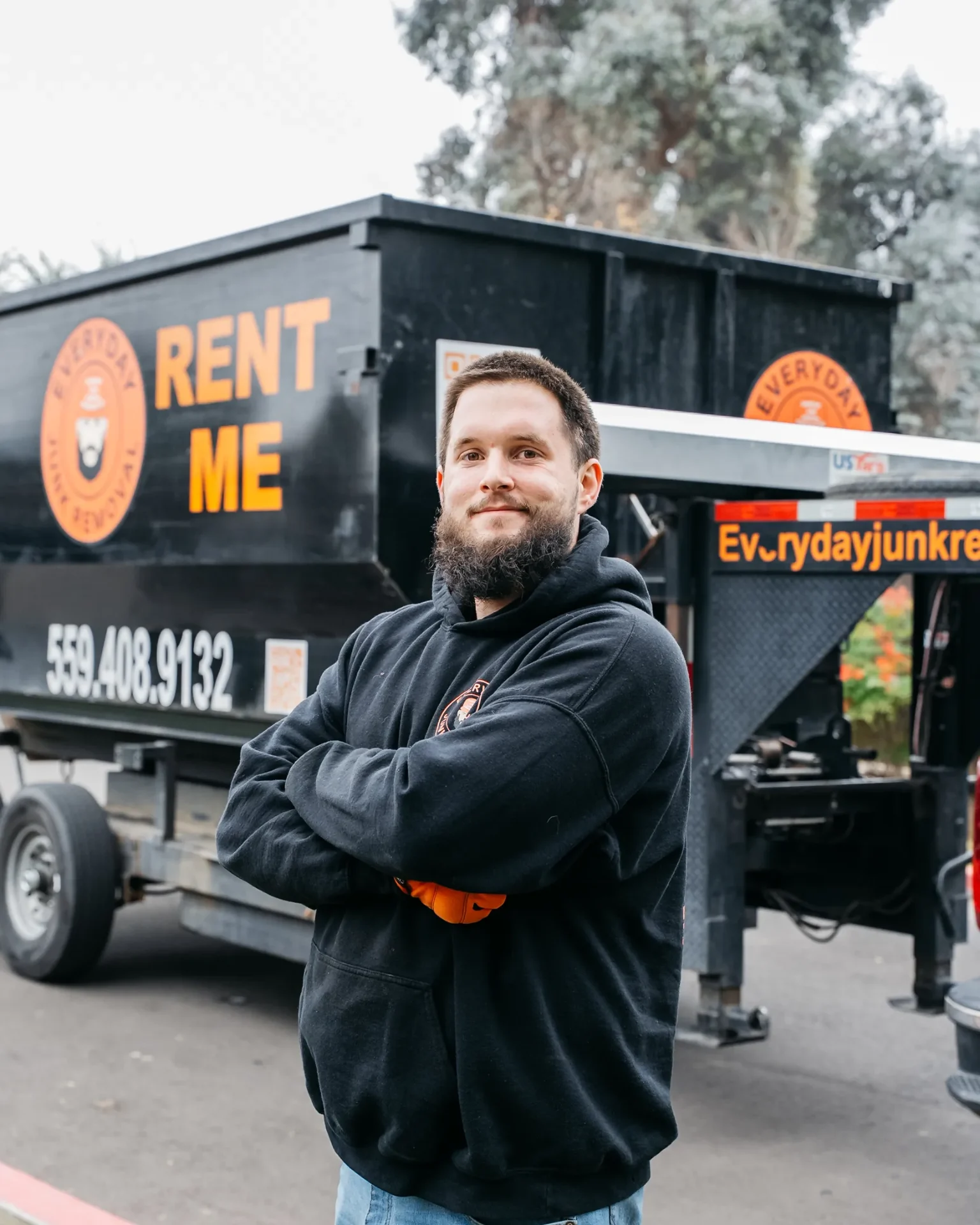 Everyday Junk Removal owner standing in front of a Rent Me dumpster